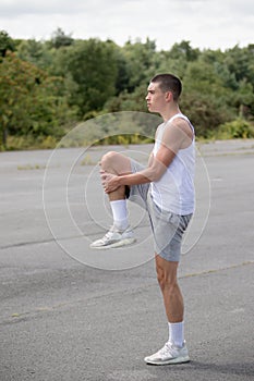 A 19 Year Old Teenage Boy Stretching In A Public Park