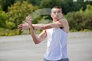 A 19 Year Old Teenage Boy Stretching In A Public Park