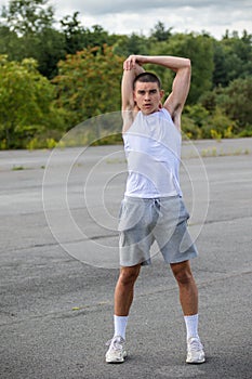 A 19 Year Old Teenage Boy Stretching In A Public Park