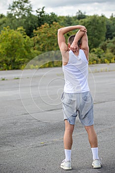 A 19 Year Old Teenage Boy Stretching In A Public Park