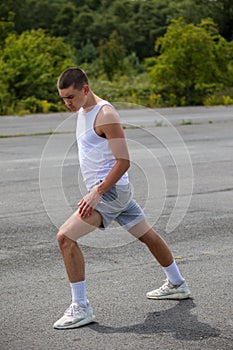 A 19 Year Old Teenage Boy Stretching In A Public Park