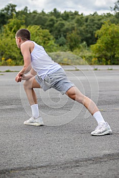 A 19 Year Old Teenage Boy Stretching In A Public Park