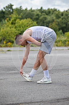 A 19 Year Old Teenage Boy Stretching In A Public Park