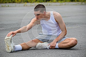 A 19 Year Old Teenage Boy Stretching In A Public Park