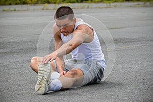 A 19 Year Old Teenage Boy Stretching In A Public Park