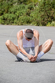 A 19 Year Old Teenage Boy Stretching In A Public Park