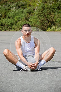 A 19 Year Old Teenage Boy Stretching In A Public Park