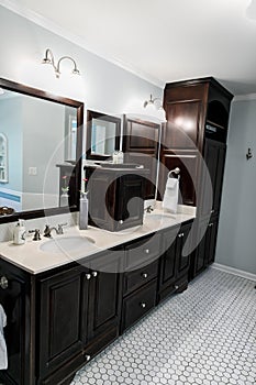 1950`s style bathroom with tile floor and dark brown cabinets in white and blue accents