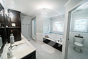 1950`s style bathroom with tile floor and dark brown cabinets in white and blue accents