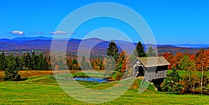 19th Century covered bridge in rolling green mountains of Vermont HDR.