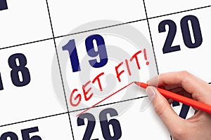 19th day of the month. Hand writing text GET FIT and drawing a line on calendar date. Save the date.