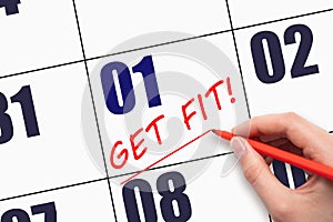 1st day of the month. Hand writing text GET FIT and drawing a line on calendar date. Save the date.