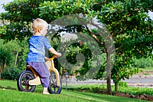 2 - 3 years joyful child riding a wooden balance bike