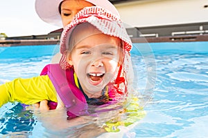 2-3 years old child with mother in swimming pool learn to swim. Summer at home concept