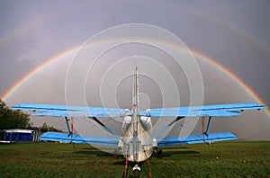 AN-2 airplane on the airfield. Rainbow over the sky