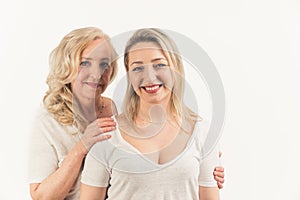 2 beautiful blonde women. Shot of a attractive mom and her young daughter over white background in the studio