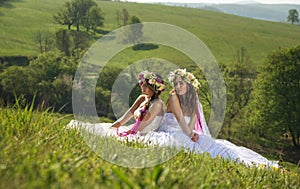 2 Beautiful bride in the outdoor, sitting on the grass - idyllic