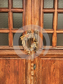 2 brass statues and a wreath of dried flowers on an old wooden door