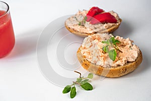 2 canapÃ©s with salmon spread and fresh cheese, leaf, part of glass of juice