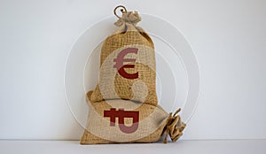 2 canvas bags with simbols of russian ruble and euro standing at different heights. Conceptual picture symbolizing cross currency