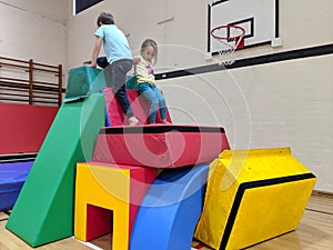 2 children climbing to the top of a soft play fort