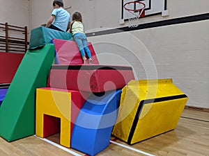 2 children looking over the edge of a soft play fort