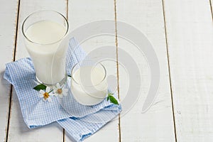 2 cups of milk placed on a white wooden table