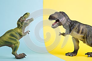2 dinosaurs fighting on a yellow and blue background