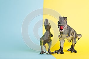 2 dinosaurs fighting on a yellow and blue background