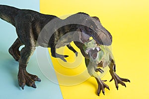 2 dinosaurs fighting on a yellow and blue background