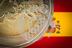 2 Euro coin with a blurred flag of Spain on the background