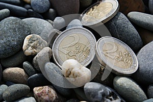 2 euro coins in pebbles. Three two euro coins.