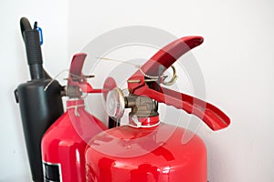 2 fire extinguishers on the white leather wall.