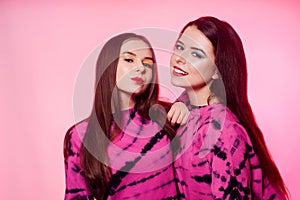 2 girls in the same things with bright makeup. Brunette girls, sisters, girlfriends, twins. Women`s power, March 8, Women`s Day.