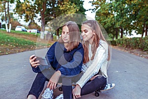 2 girls schoolgirls teenagers 13-15 years old, autumn day, summer in city, holding smartphone, happy laughing joyful