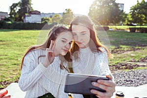 2 girls, schoolgirls, teenagers 13-15 years old, in fall day, in summer in city, selfie on smartphone, online