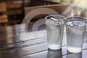 2 Glass with ice and cold water on wood table