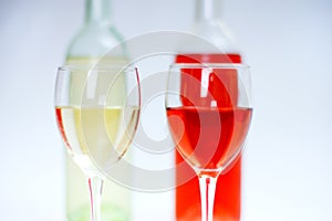 2 glasses of white and rose wine with bottles and white background photo