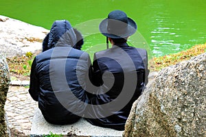 2 Hasidic men, Jewish family, in traditional clothes read a prayer in the park in Uman, Ukraine, the time of the Jewish New Yea