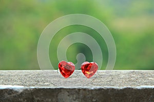 2 hearts on the cement floor The green background.