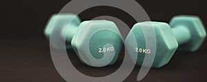 2 kg dumbbells isolated on dark background - home fitness and workout