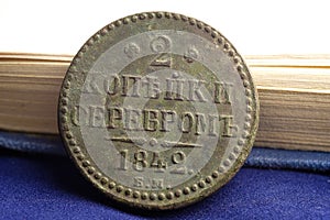 2 kopecks in silver in 1842 Russian money, vintage items close-up and a book