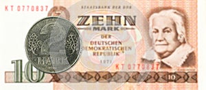 2 mark coin against historic 10 east german mark bank note