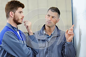 2 mechanic men looking at problem