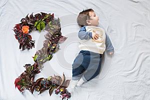 2 months baby. Two months old boy at home on the couch. figure 2 is laid out from the foliage. Top view, flat lay