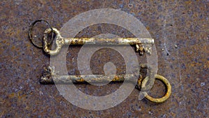 2 old rusty keys on ring shot on steel textured background. Copy space.