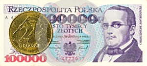 2 polish groszy coin against 100000 polish zloty bank note