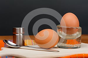 2 soft-boiled eggs on a wooden board.