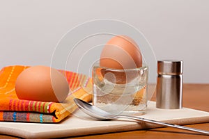 2 soft-boiled eggs on a wooden board.