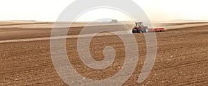 2 tractors pulling planting implements in an Idaho farm field.